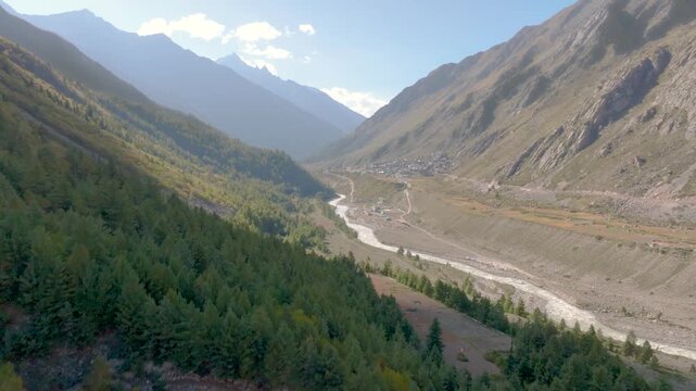Cinematic drone flight pushing forward into the remote, pristine Baspa River valley in the Chitkul, Himalayas.
