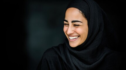 Naklejka premium Young woman laughing with eyes closed in dark studio portrait