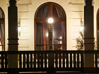 Warm glow on glass surface. Serene scene of nighttime window with soft drapes and warm illumination © Vladimir