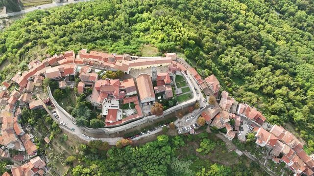 Cinematic drone shot of Motovun hilltop village in Istria Croatia with wide panoramic view of Mirna valley, green fields and vineyards, scenic rural landscape perfect for travel and tourism