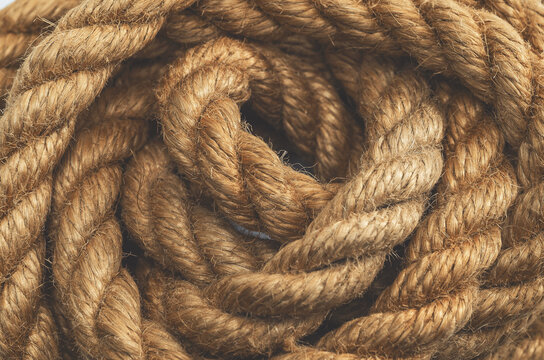 Macro photo of twisted brown rope. Top view. Fibers and rope structure. Brown thread background.