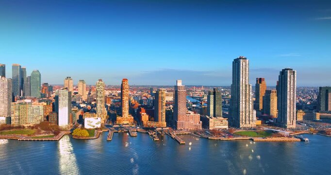 Lower Manhattan skyline in New York City looking south over the Hudson River. Western shoreline with buildings lit with bright sun.