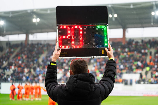 Official holding a digital substitution board showing player numbers nine and seventeen during a professional football match at a stadium.