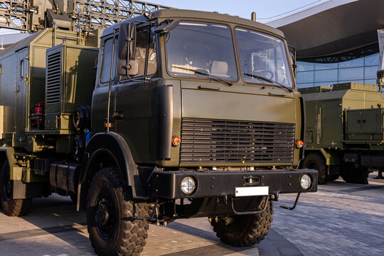 Military equipment and army equipment.. Mobile command truck parked near pavilion, communications modules and antennae visible, signals equipment and rugged shelter indicate field operations