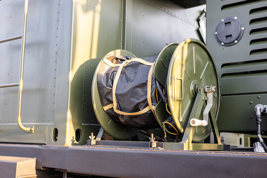A drum with a wound cable on an armored personnel carrier in close-up.