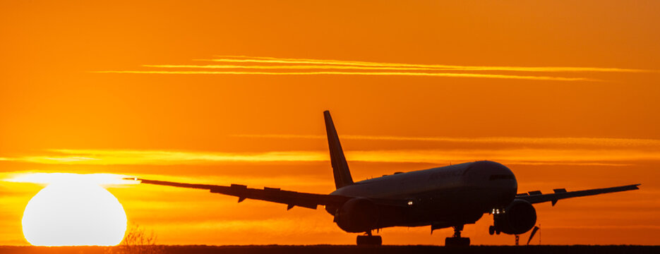 Atterrissage d'un avion de ligne au coucher du soleil