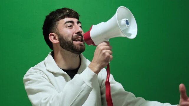 Passionate bearded man making an announcement and protesting with a megaphone. A political activist speaking loudly at a rally on a green screen