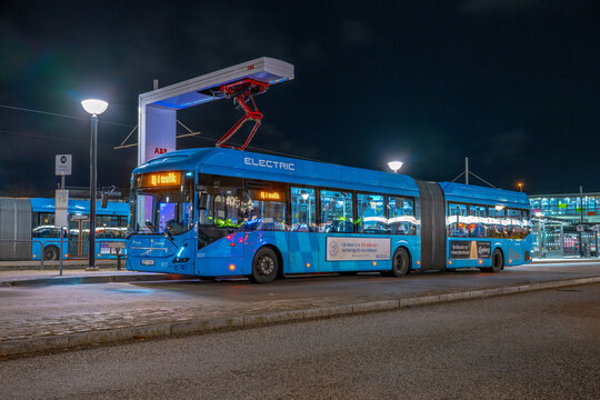 Gothenburg, Sweden - november 16 2023: Electric articulated city bus charging at night station.