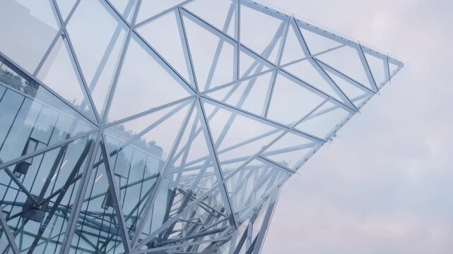 Abstract decorative frame of glass and metal on skyscraper top against evening sky. Trends of contemporary architecture in downtown block
