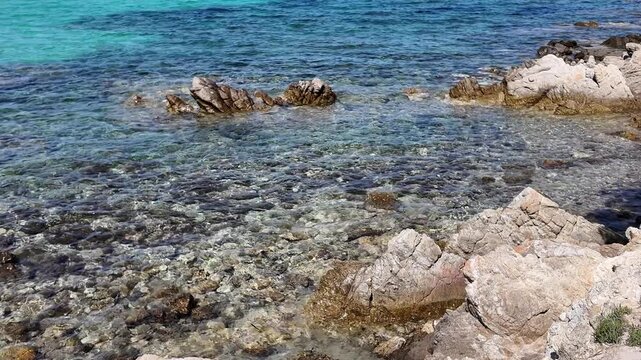 Clear shallow sea water with stones underwater Italy Sardinian Rena Bianca