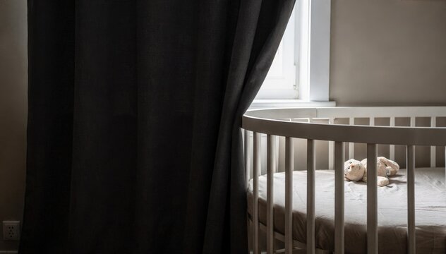 Focused view of blackout curtains being drawn over a crib zone creating a calm darkened nap environment.