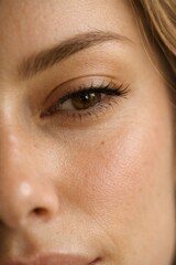 Fototapeta premium Close-up portrait of a woman with captivating eyes. Natural beauty shines through soft lighting. This vertical image highlights features and evokes a sense of tranquility and confidence.