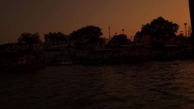 Beautiful sunset view at Guptar Ghat on the Sarayu River in Ayodhya, Uttar Pradesh. Calm flowing water, a long bridge silhouette, and warm golden sky, creating a peaceful spiritual atmosphere.