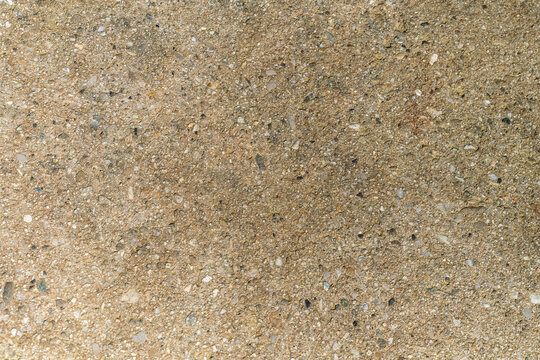 Texture de sol sablonneux beige avec petits min&eacute;raux et gravillons en gros plan
