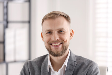 Naklejka premium Portrait of smiling businessman in suit in office