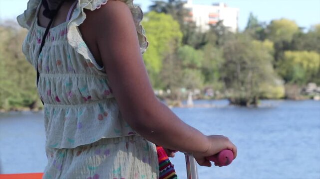Young girl riding scooter along riverfront in roanne, france