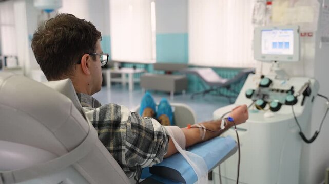 Male blood donor giving blood in a hospital donation center