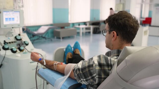 Male patient donating blood in a modern hospital clinic