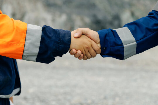 Industry workers handshake close up at gravel site mining