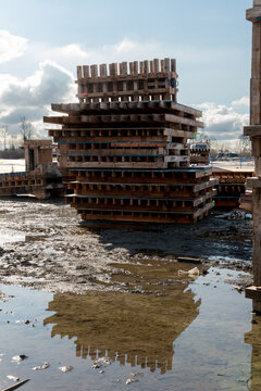 Canada, BC, Vancouver.  A stack of wooden pallets at a muddy construction site. 
