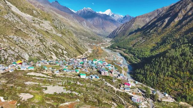 Epic aerial view of Rakcham village in the Baspa Valley with majestic snow-capped Himalayan peaks in the background.