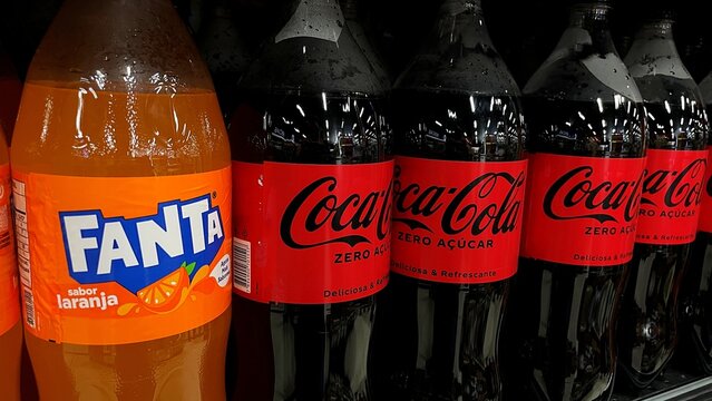 Salvador, Brazil - April 9, 2026: Plastic bottles of Fanta Orange and Coca-Cola soft drinks on a supermarket shelf. 