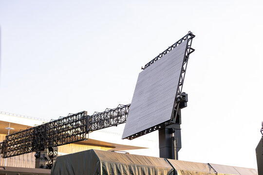 Military equipment and army equipment.. Large phased array radar panel mounted on vehicles in field deployment, tactical sensor oriented for longrange detection, covered support trucks,