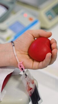Male patient squeezing stress ball during blood donation