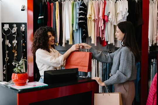 Retail worker handing shopping bag to customer