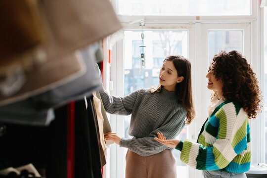 Young women shopping for clothes in modern boutique