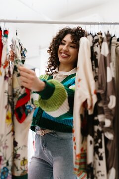 Happy customer choosing clothes from a retail rack