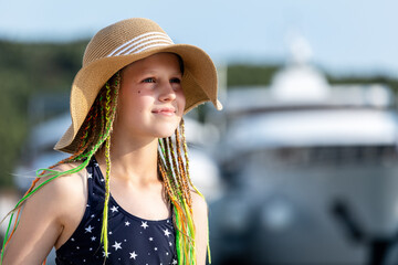 Girl wearing straw hat swimsuit stand sea luxury yachts marina during sunny summer vacation. Travel...