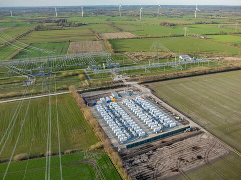 Grid-scale battery storage and substation in rural energy landscape. Large-scale battery energy storage system (BESS) installation within rural agricultural landscape. 