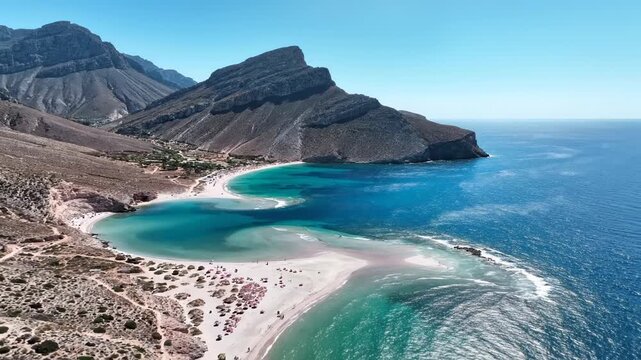 Coastal Paradise Beach with Crystal Blue Water and Jagged Mountains