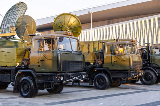 Military equipment and army equipment.. Modern field vehicles with antennas and dishes stationed. Arranged military radar trucks featuring parabolic antennas on heavy chassis