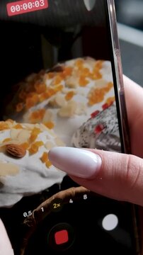 Italian Easter bread colomba pasquale arranged on table as female hands film soft paska and kulich on mobile phone for food blog with festive bakery details