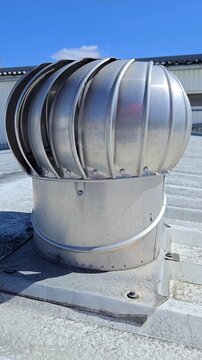 Rotating turbine vent on a metal roof for industrial ventilation and energy saving