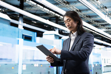 Fototapeta premium Microchip production, tablet and businessman in foundry facility studying components metrics. analyzing data, touchscreen device and senior manager overseeing semiconductor production plant operations