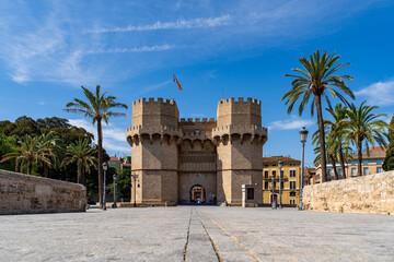 Torres de serranos stands as a medieval gothic gate with palm trees and a bridge © Marino Bocelli