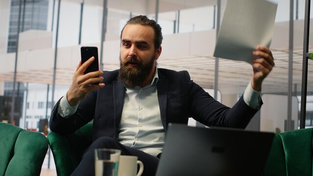 Entrepreneur getting angry and scolding his staff on video call, throwing papers with an aggressive dissatisfaction. Outraged boss accusing his associates of incompetence, bad leadership. Camera B.