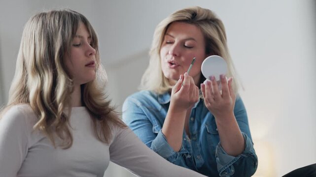 Mother and daughter doing makeup together at home