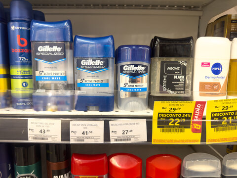 A well-stocked supermarket shelf displays a variety of mens deodorants and antiperspirants, featuring prominent brands like Gillette and Nivea with clear pricing