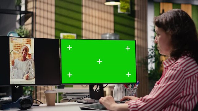 Mockup green screen next to media short clips on PC monitor, male production specialist checking online content on platforms. Boosting monetization numbers based on marketing insights.