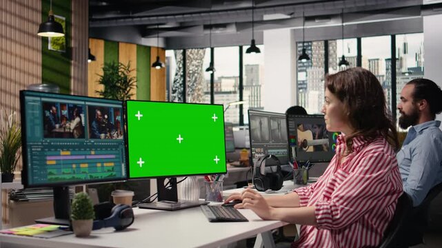 Green screen with video editing montage on computer used by filmmaker, raw recorded clips on software. Woman working with cutting controls and color grading adjustments, post production.