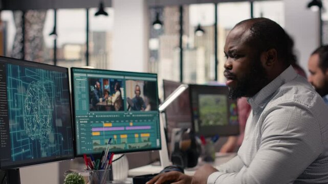Black videographer refining footage with artificial intelligence tools in a high-tech post production agency. Editing software displays wireframe and data optimization powered by neural networks.