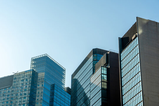 Low angle view of modern skyscrapers against clear blue sky in financial district, showcasing urban architecture, business growth, corporate environment and future city development concept