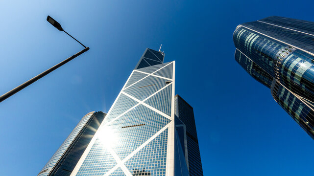 Low Angle View of Iconic Modern Glass Skyscraper Rising Against Deep Blue Sky