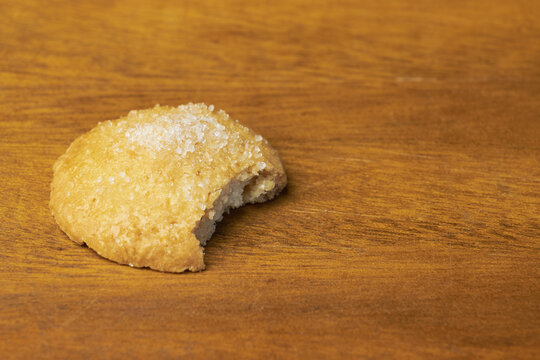 Bitten sugar cookie on a wooden table