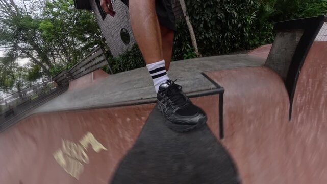 Point of view of a skateboarder dropping into a ramp at a skatepark