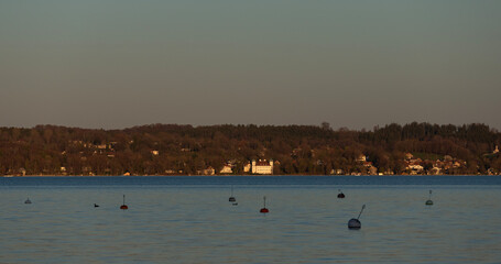 Calm lake water with mooring buoys and distant shoreline © Chanawat
